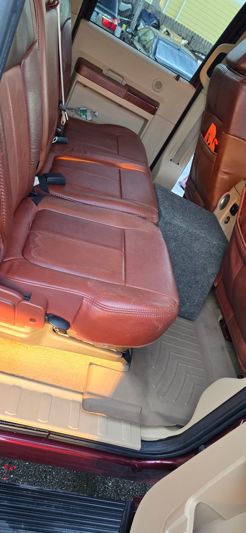 Brown leather seats inside a vehicle cabin with a narrow aisle and beige interior panels