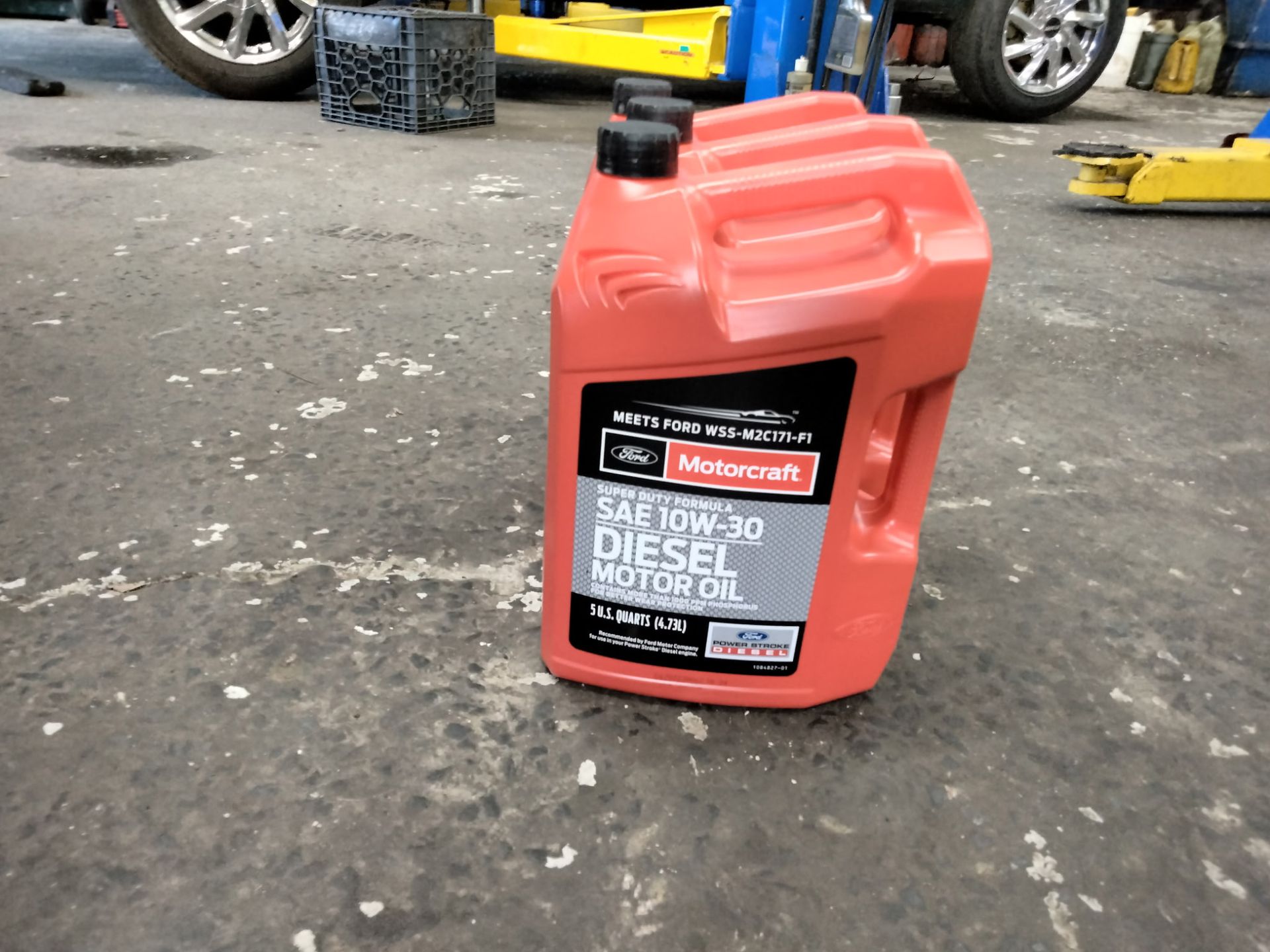 Red diesel fuel container on a concrete floor in a vehicle service area.