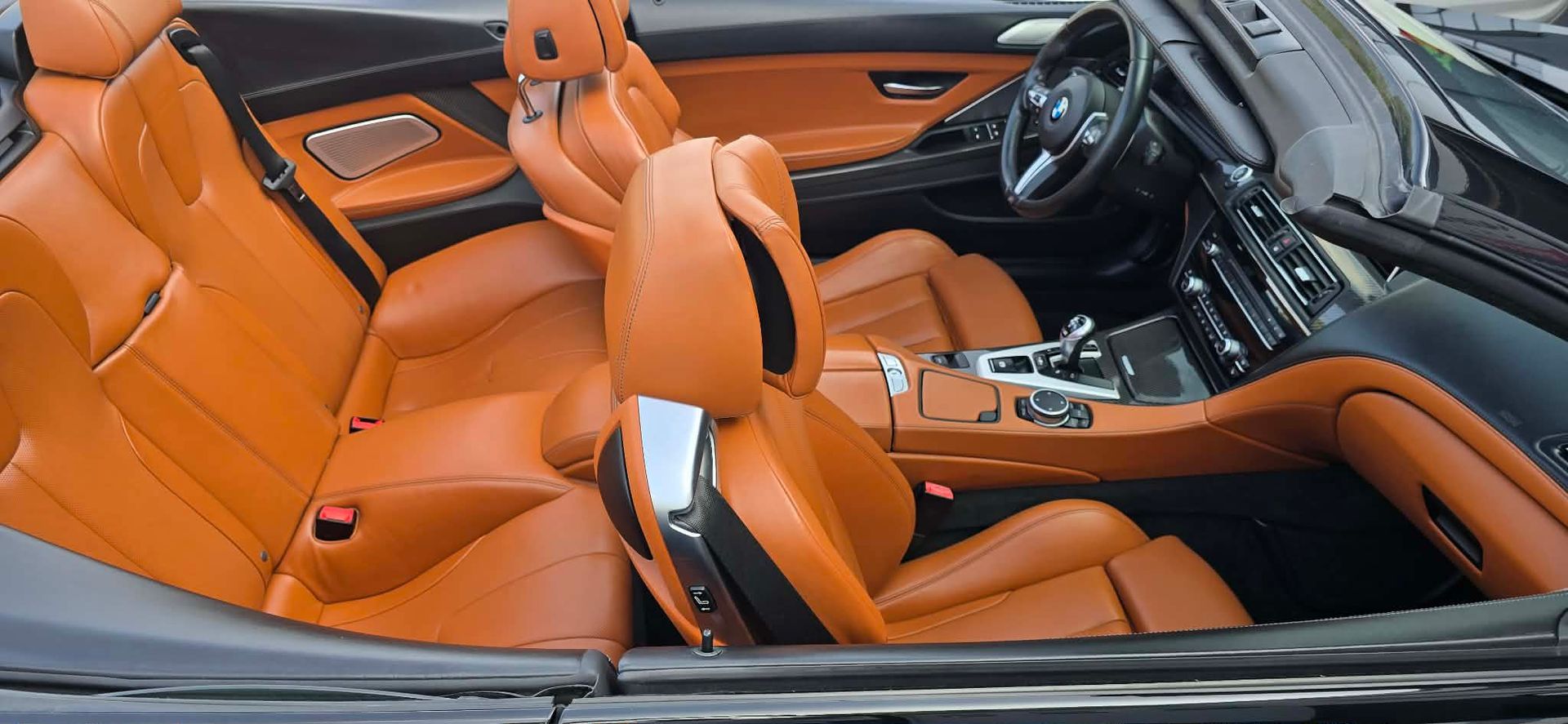 Orange leather sports car interior with black dashboard and steering wheel
