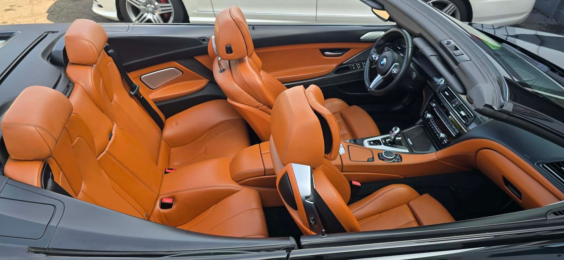Orange leather convertible sports car interior with black dashboard and steering wheel