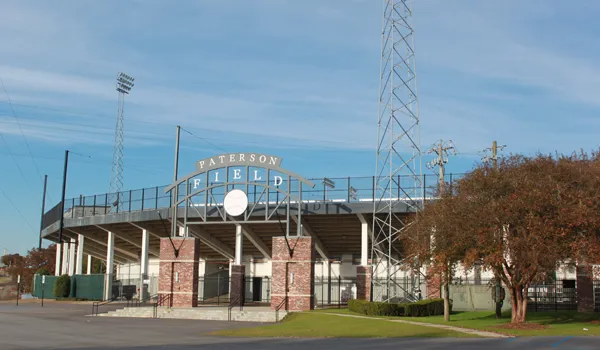 Exterior view of Paterson Field, a baseball stadium with white letters and a brick entrance.