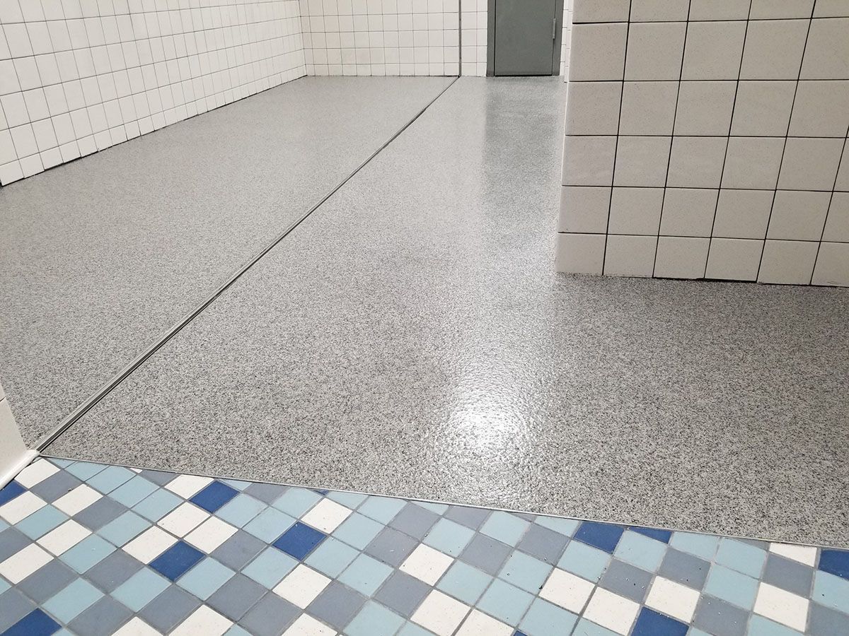 A room with a tiled floor and a brick wall.
