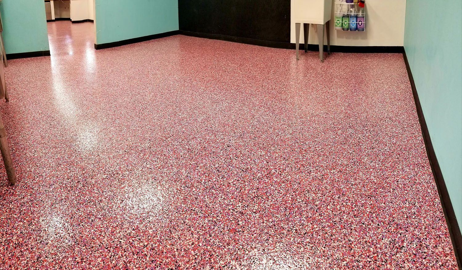 A room with a pink floor and a white sink.