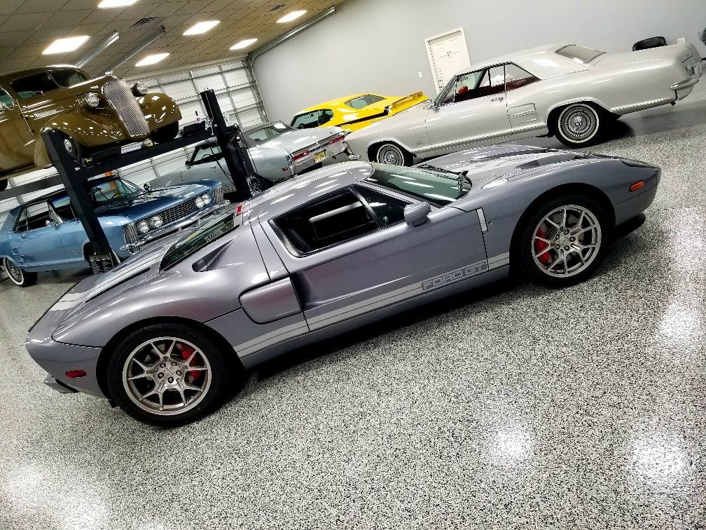 A ford gt is parked in a garage next to other cars.