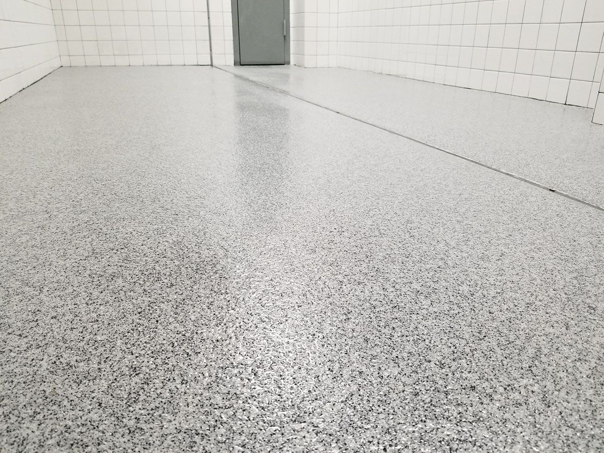 A room with a gray floor and white tiles.