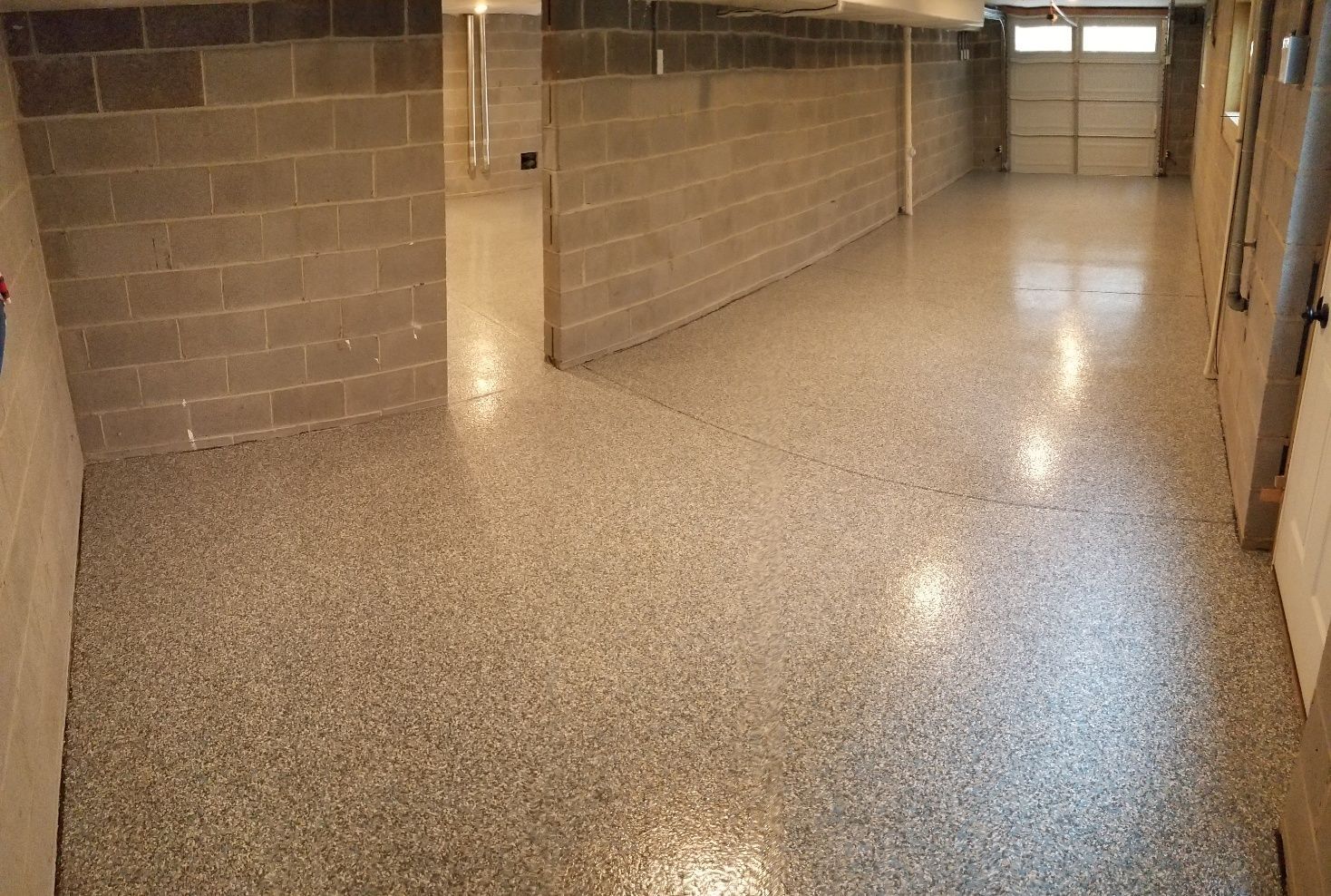 A garage with a concrete floor and brick walls.