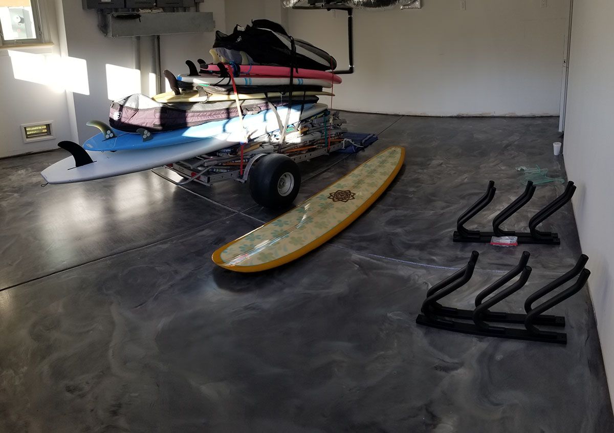 A surfboard is sitting on a cart in a garage.