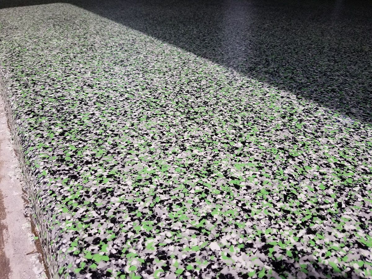 Aclose up of a green , white and black granite counter top.