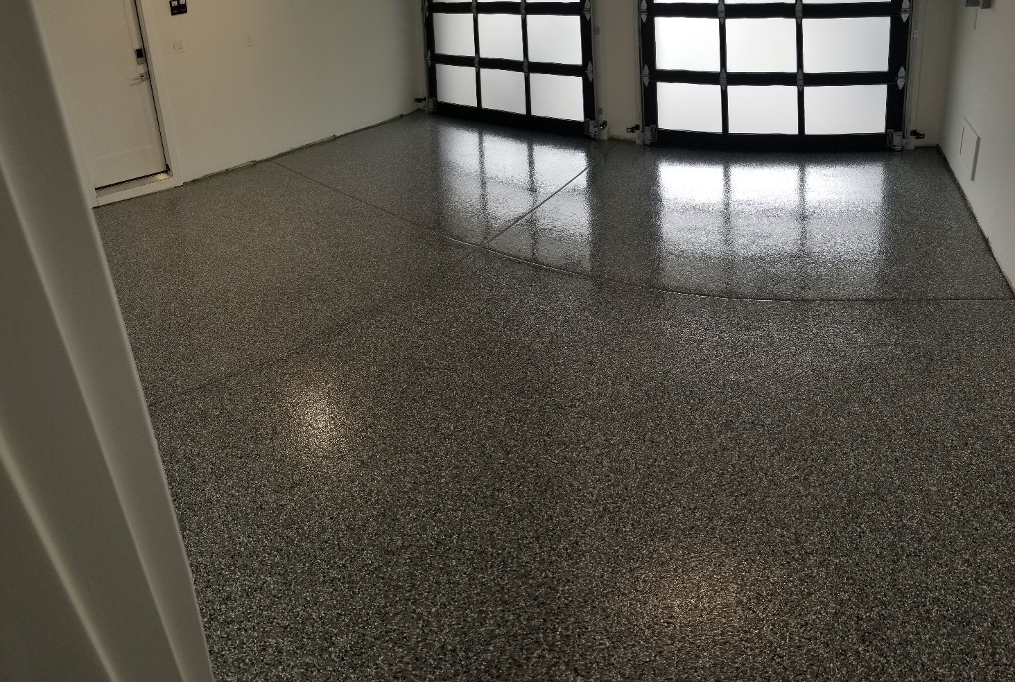 A garage with a shiny floor and a garage door.