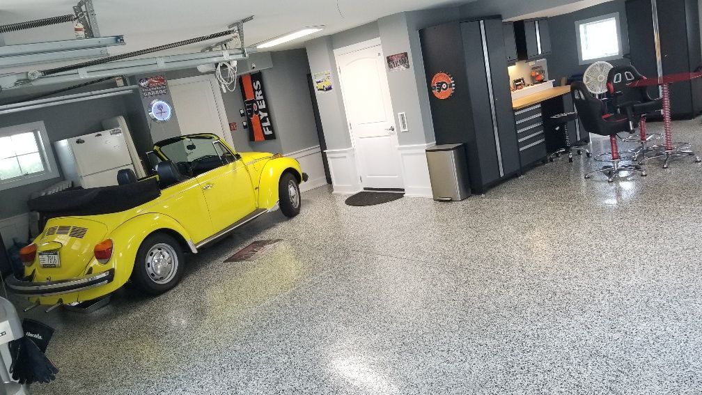 A yellow beetle convertible is parked in a garage.