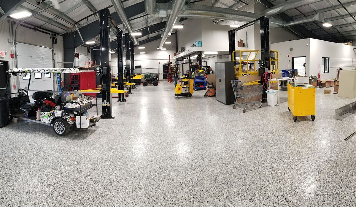 A large garage with a lot of golf carts in it.