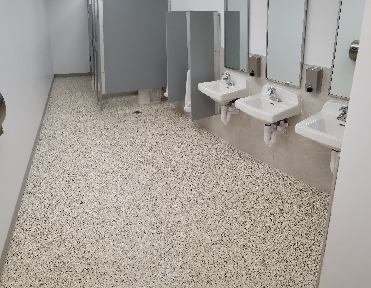A public restroom with a row of sinks and mirrors.
