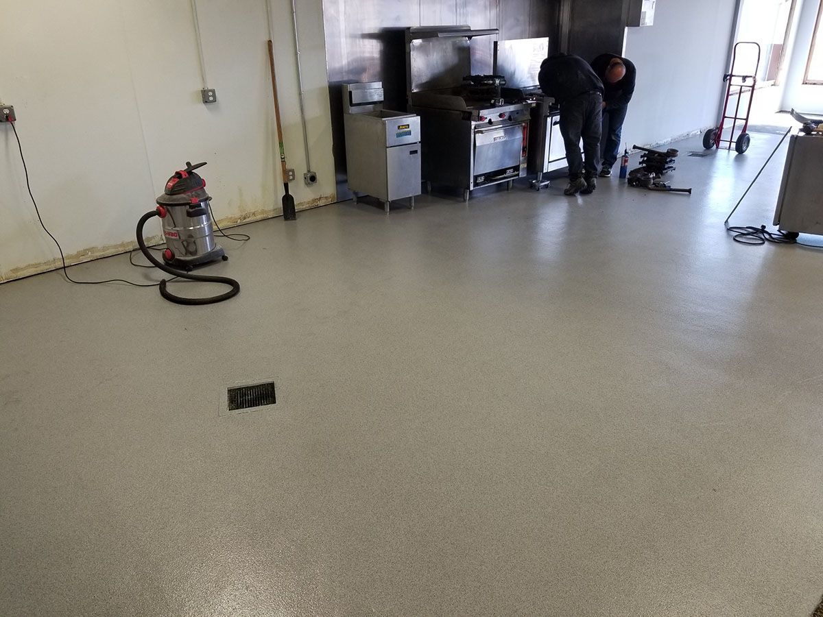 A vacuum cleaner is sitting on the floor in a kitchen.