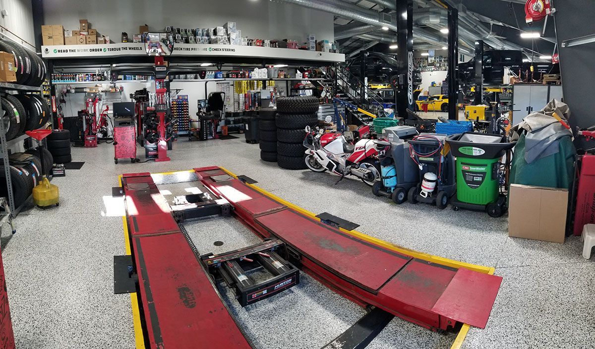A motorcycle is sitting on a lift in a garage.