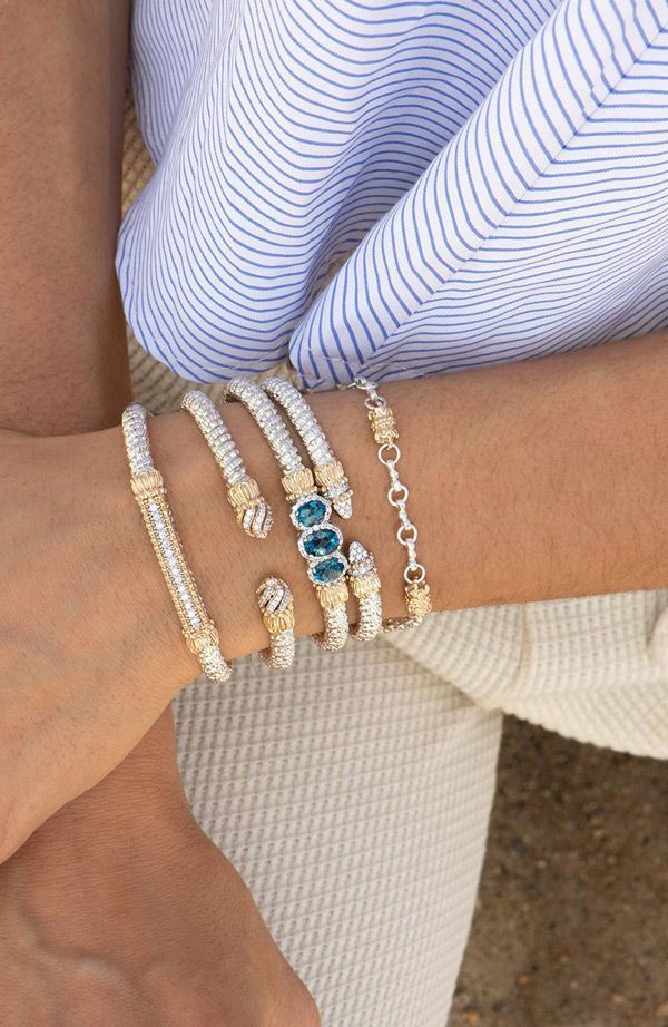 a woman is wearing a bunch of bracelets on her wrist