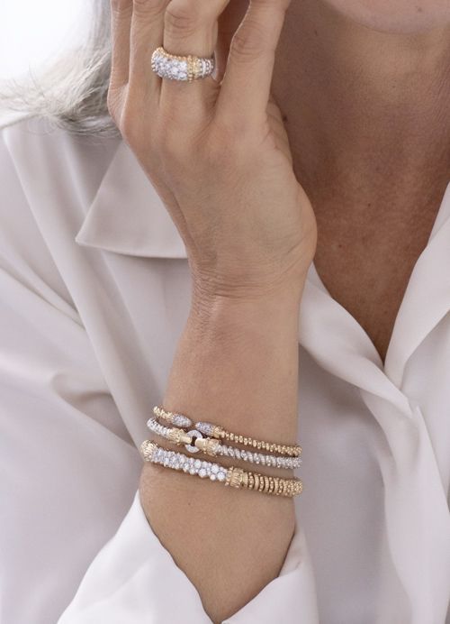 a woman wearing a ring and bracelets on her wrist