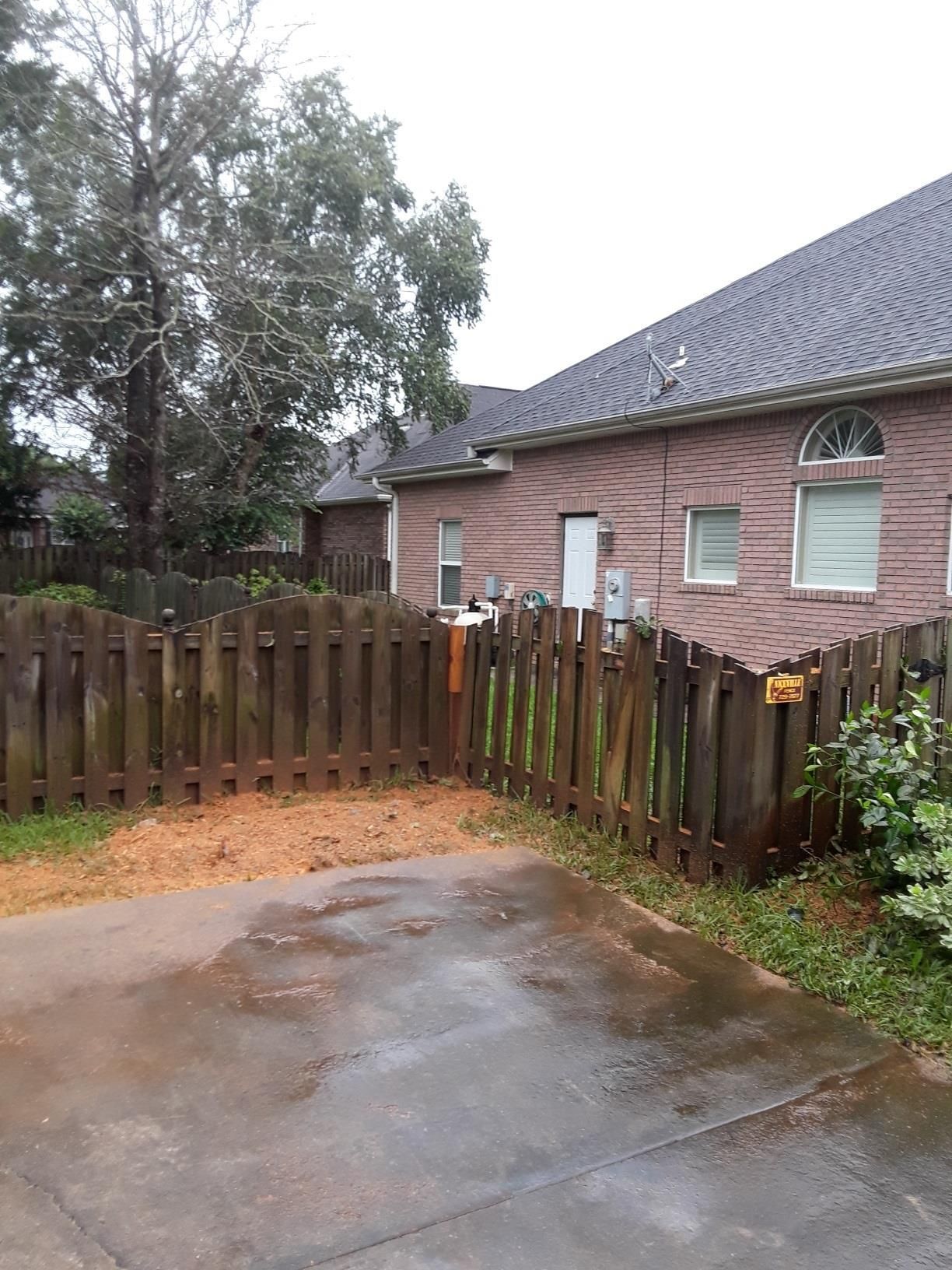 A brick house with a wooden fence in front of it