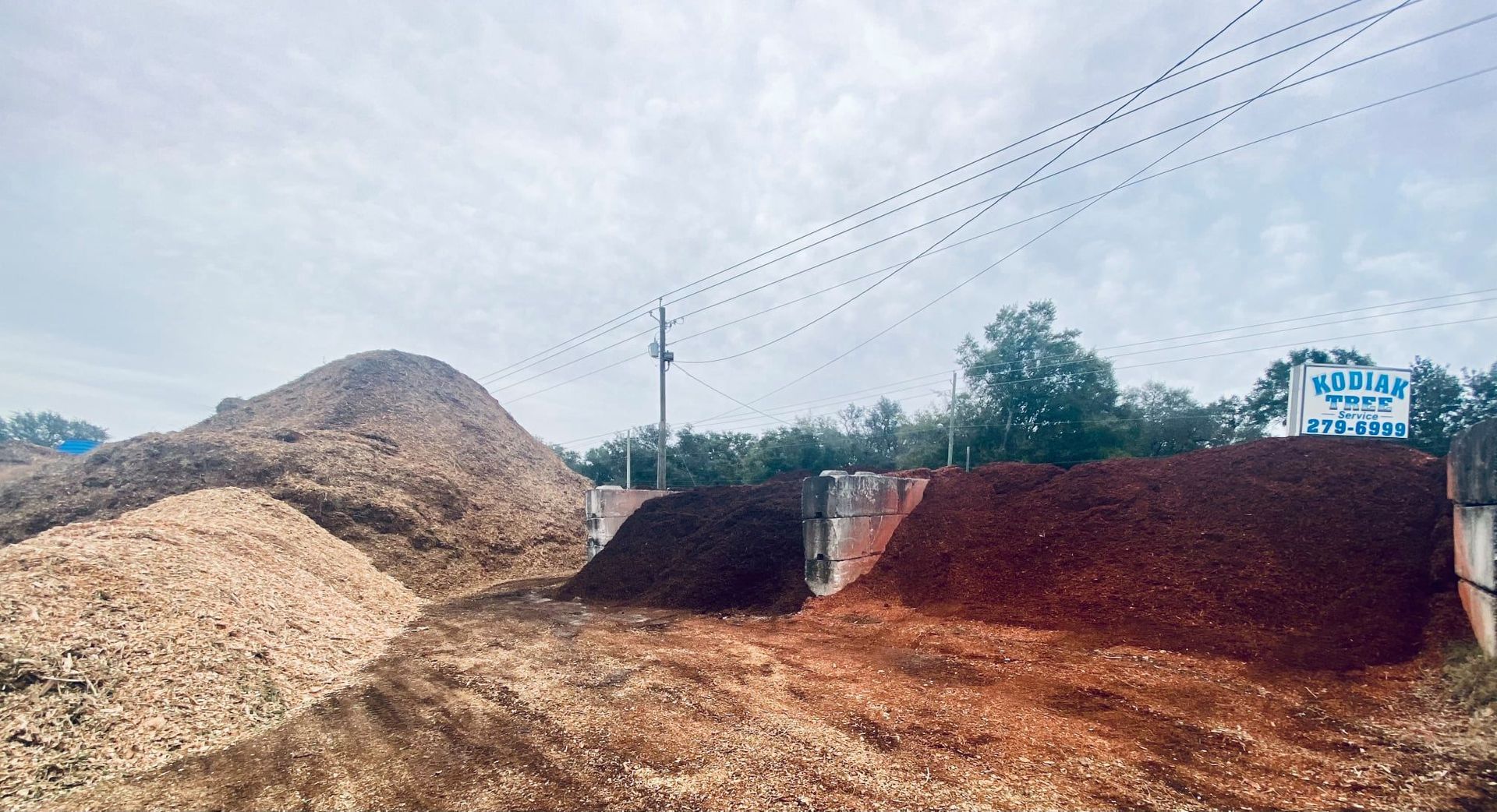 A pile of dirt is sitting next to a pile of wood chips.