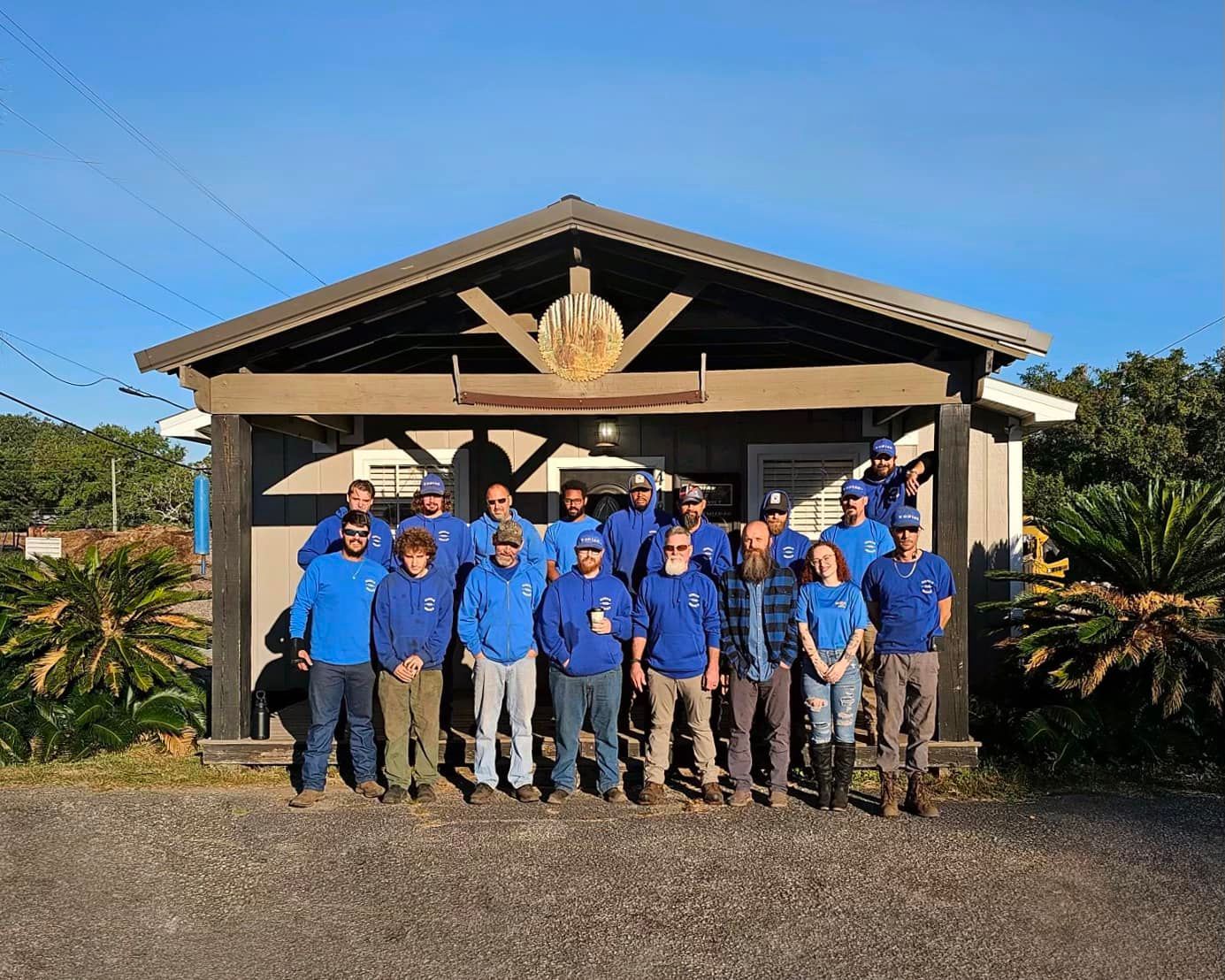 A group of people are posing for a picture in front of a building.