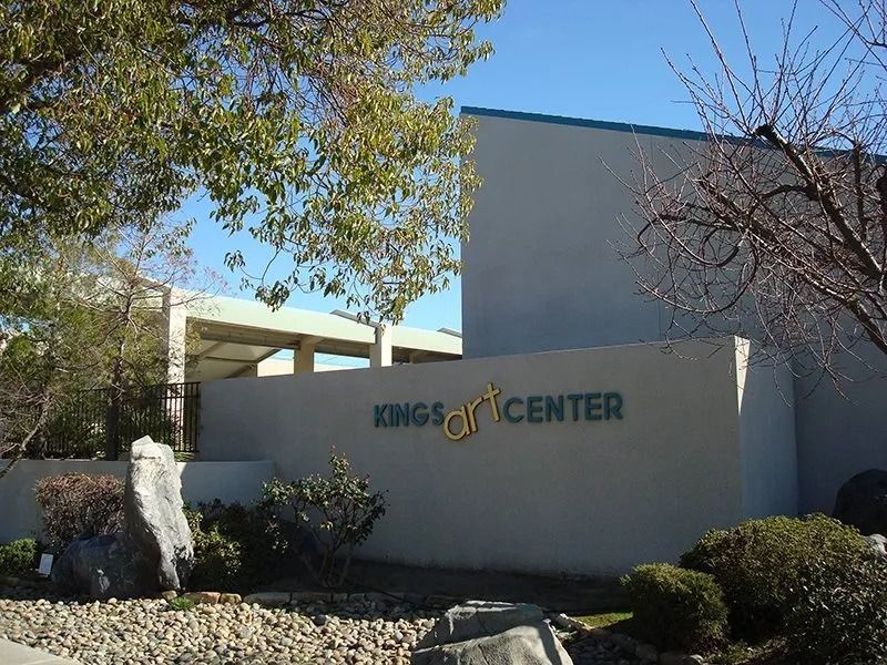 Kings Art Center building with a gray facade and a sign on a sunny day.
