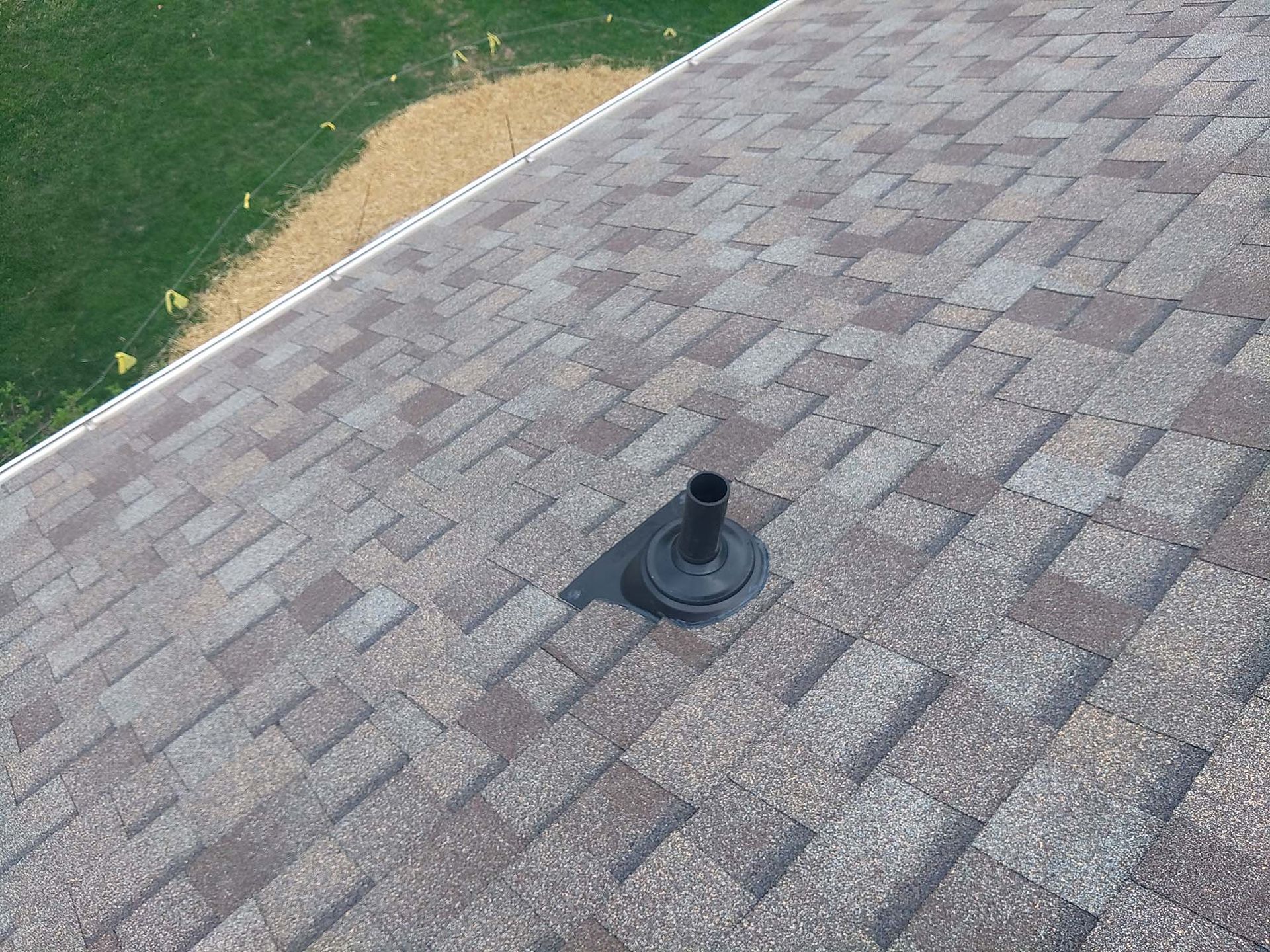 Roof with asphalt shingles and a vent pipe.
