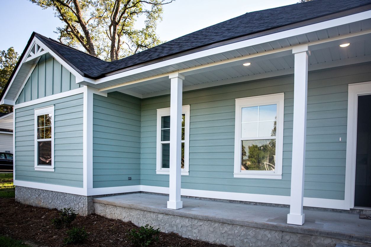 Blue house with white trim, porch with columns, and two windows.