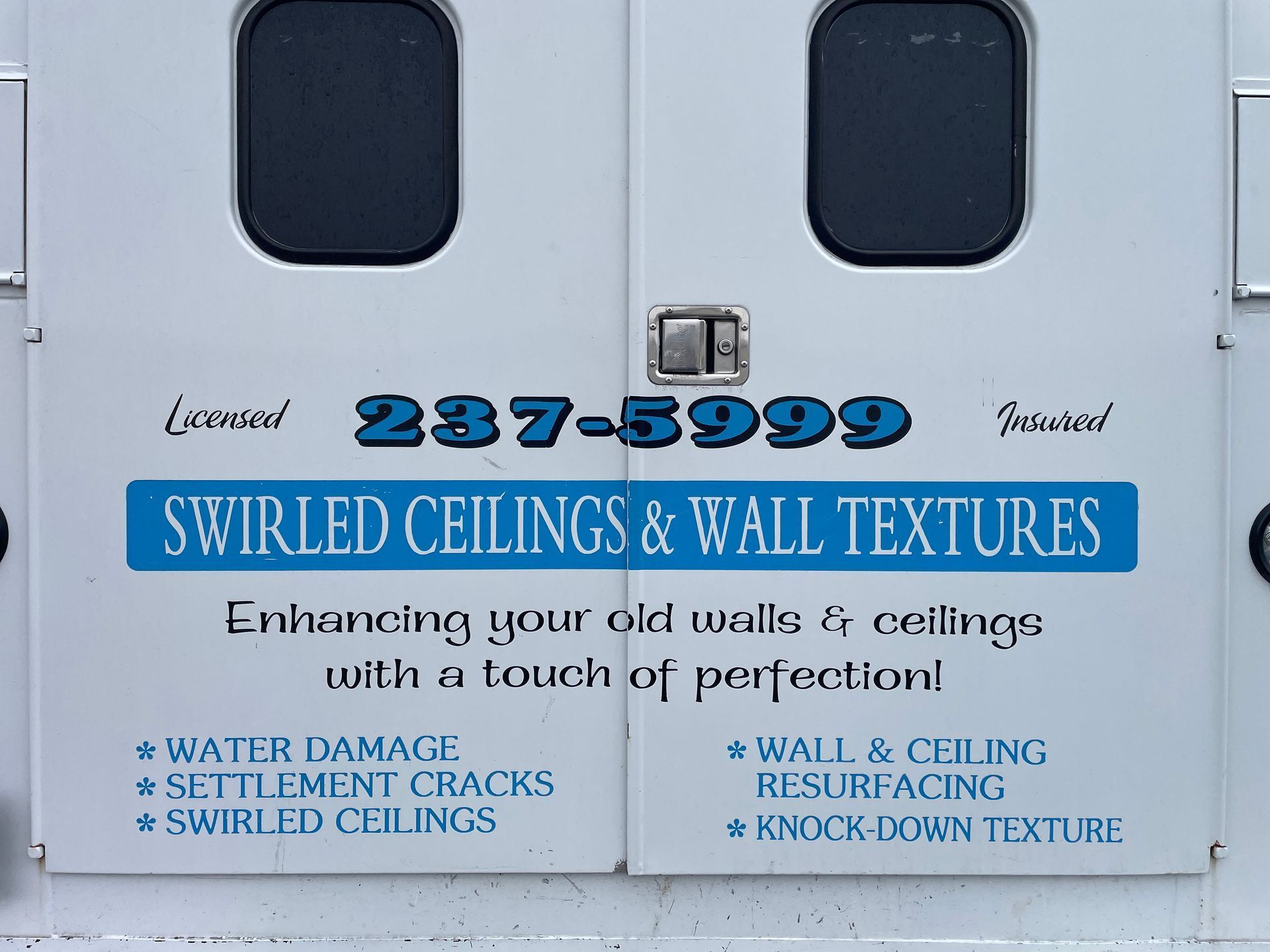 Hand using a putty knife to apply spackle to a wall.