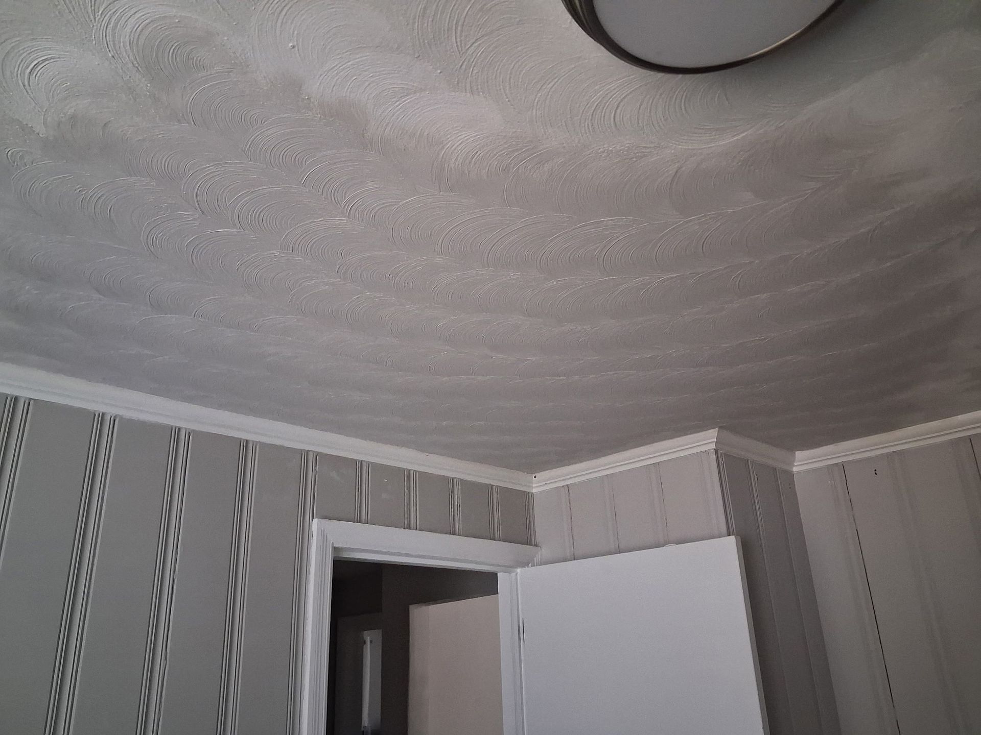 White crown molding decorates a ceiling, with intricate patterns and a corner design.