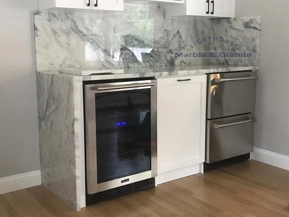 a kitchen with stainless steel appliances and marble counter tops