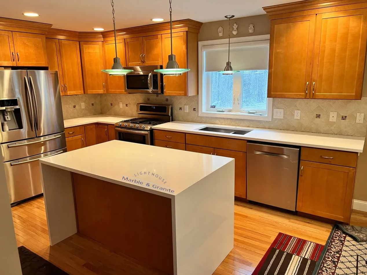 a kitchen with wooden cabinets, stainless steel appliances, and a large island