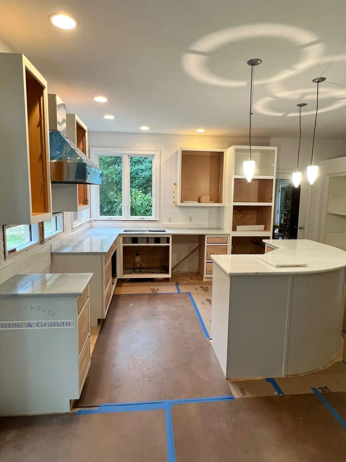 a kitchen with white cabinets and a large island