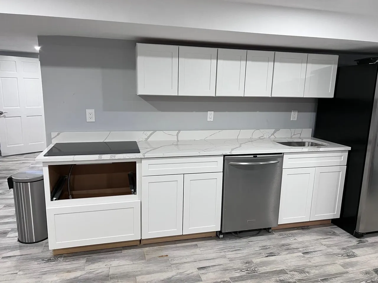 a kitchen with white cabinets and a stainless steel dishwasher