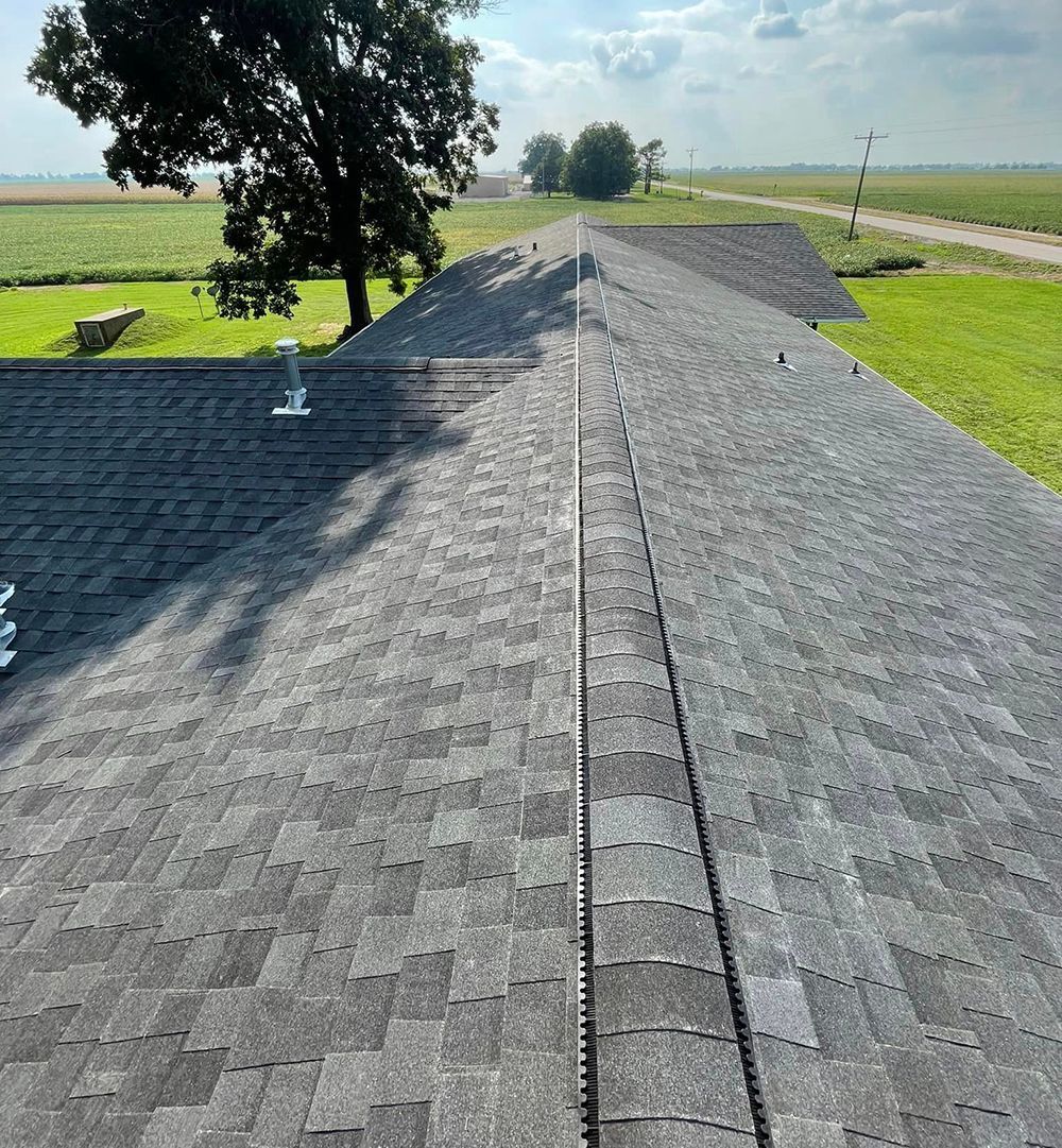 An aerial view of a roof with a tree in the background