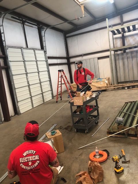 Two men are working on electrical parts for the building.