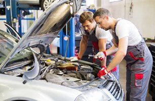 Two mechanics fixing a car