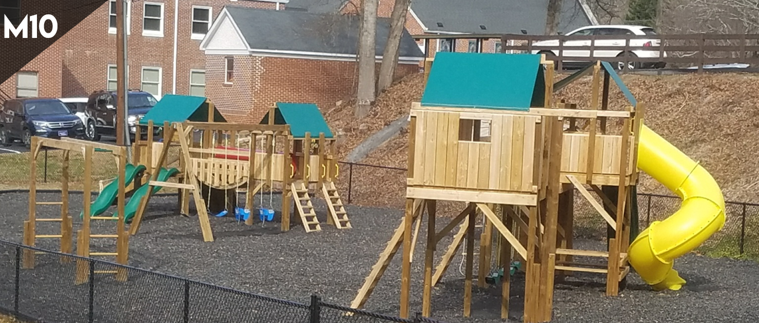 A wooden playground with a yellow slide and green houses