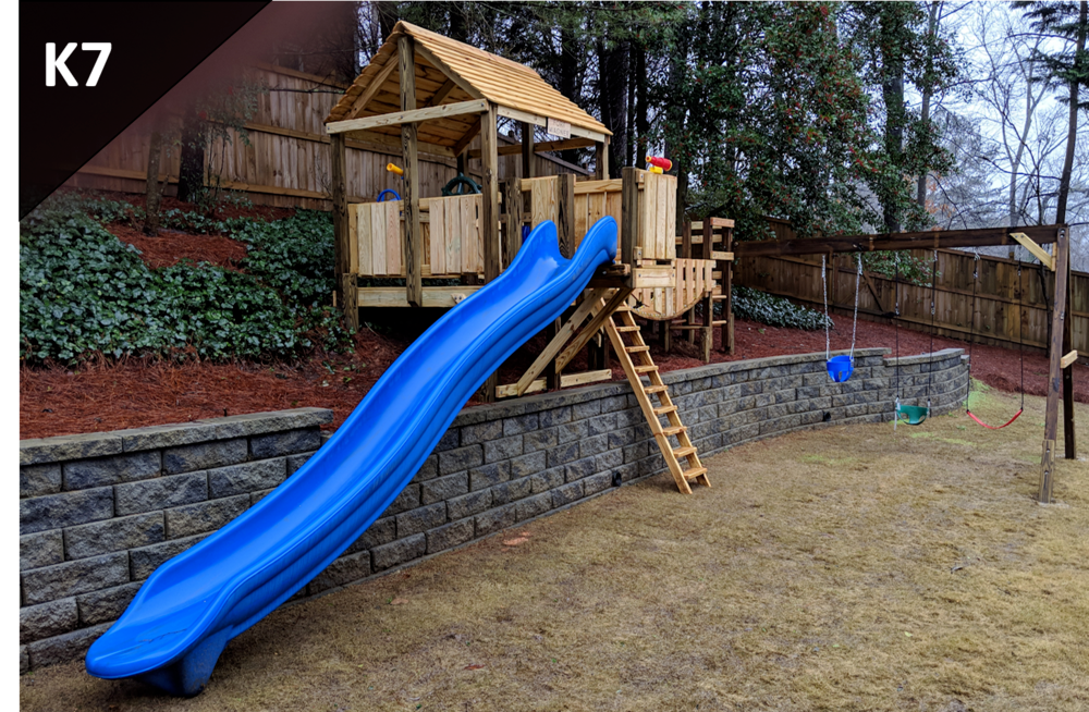 A blue slide in a playground with the number k7 on the bottom