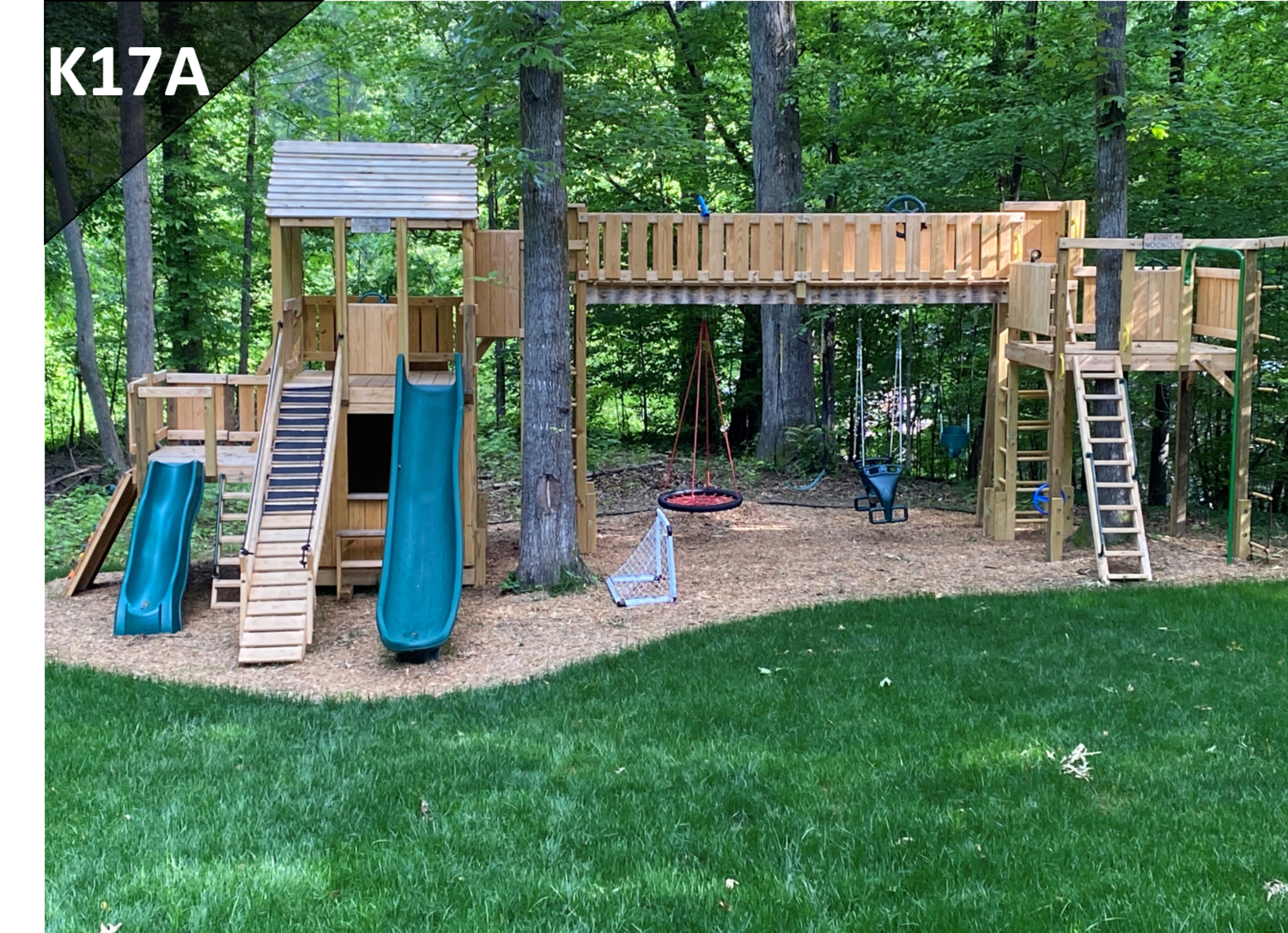 A large wooden playground with slides and swings in a backyard