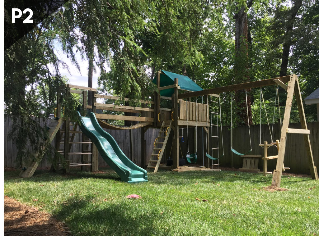 A playground with a slide and swings in a backyard.
