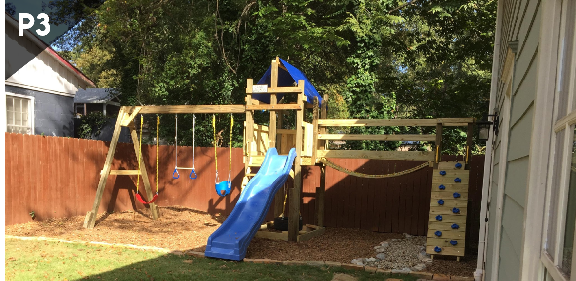 A wooden playground with a blue slide and swings in a backyard.