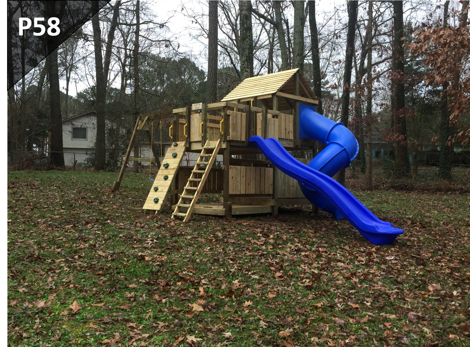 A wooden playground with a blue slide and stairs