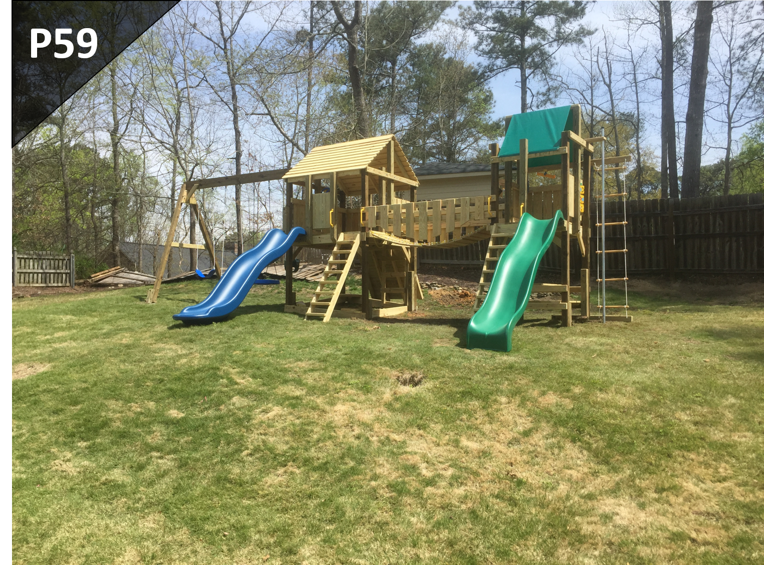 A playground set with two slides and a swing set in a backyard.