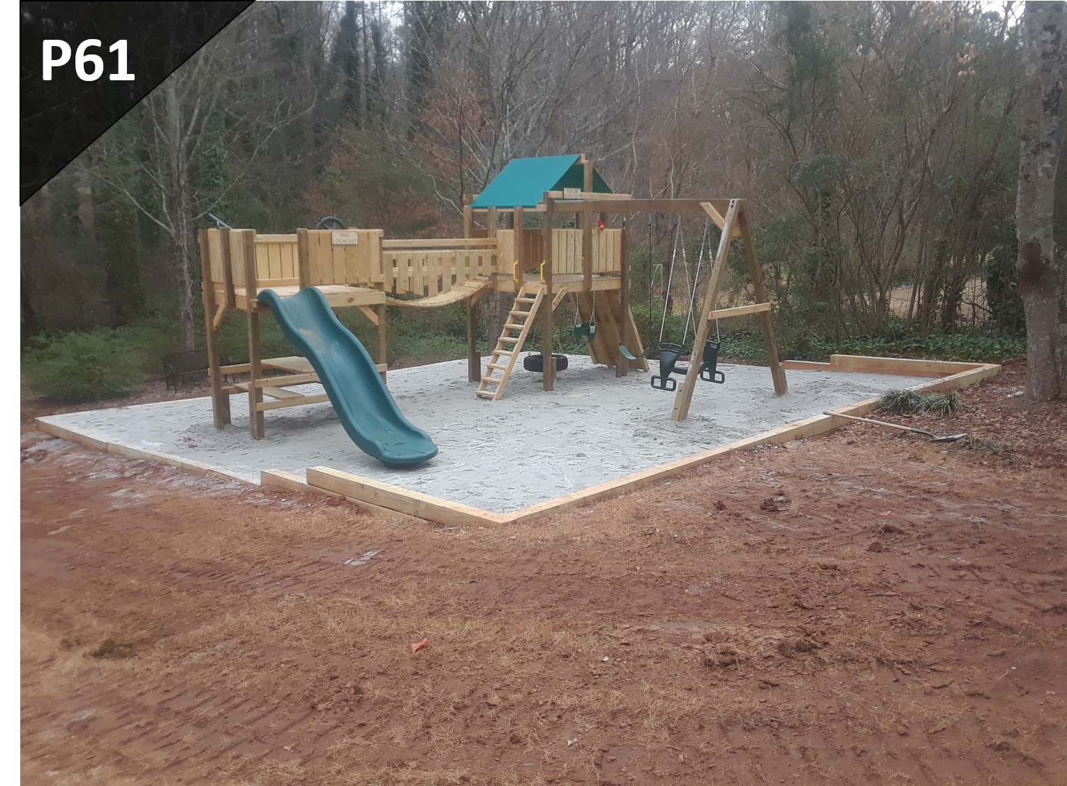 A wooden playground with a blue slide and swings