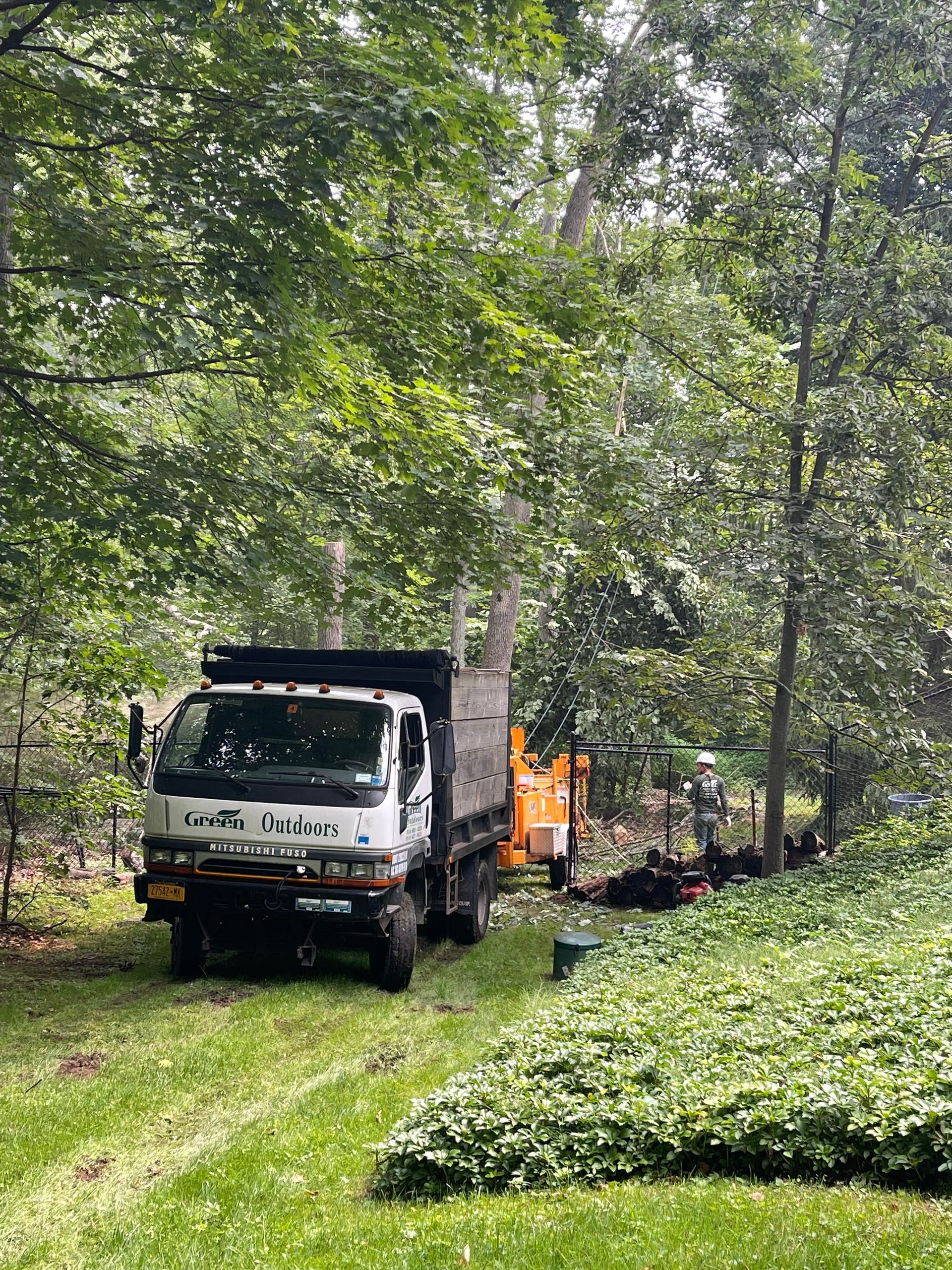 A dump truck is parked in the middle of a forest.