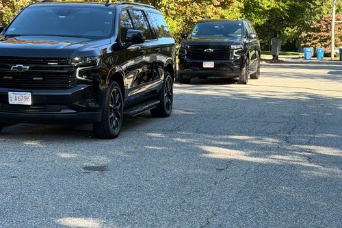 Black SUVs parked on a car lot on a sunny day
