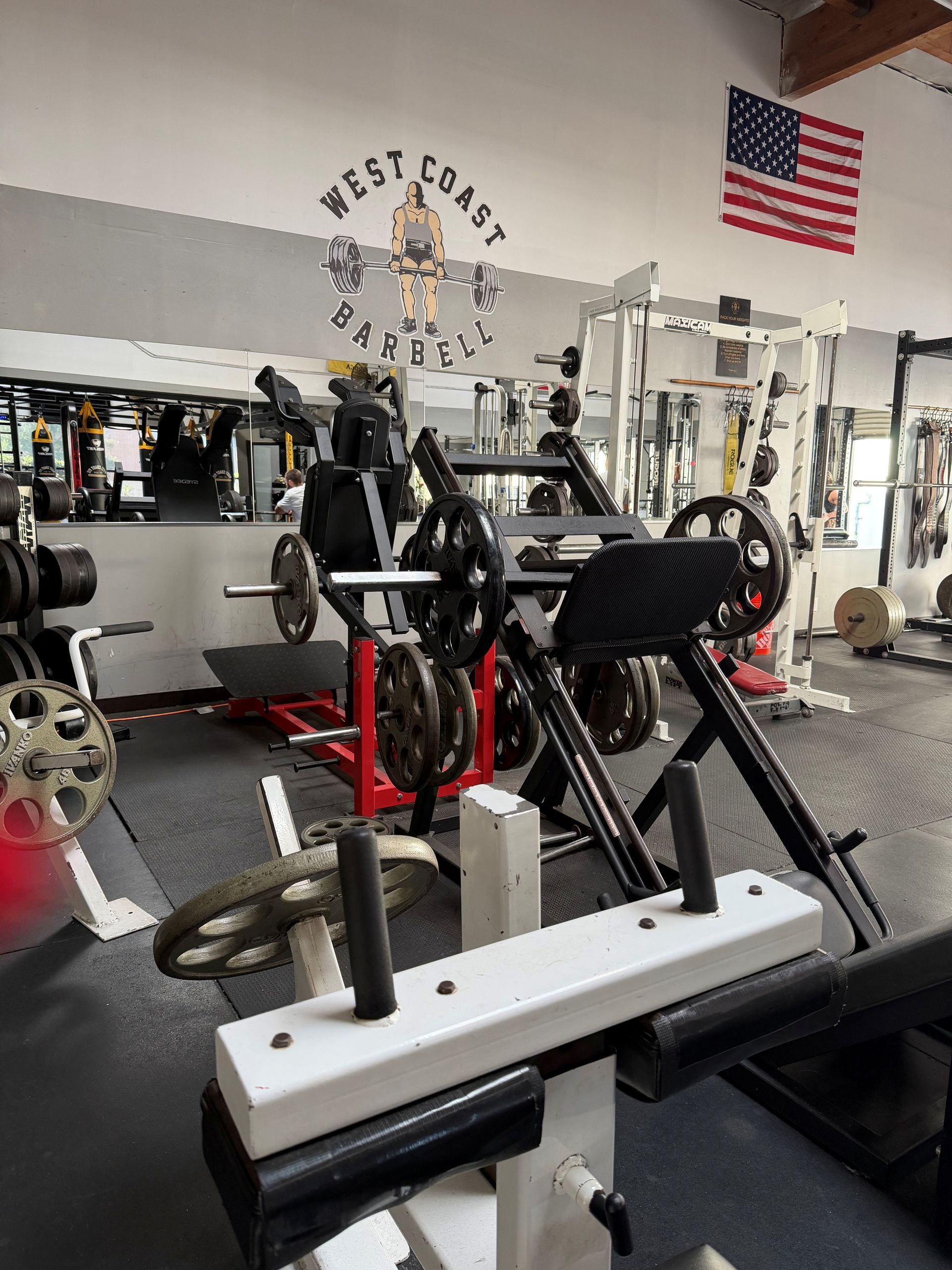 Gym interior with weight machines, an American flag, and a 