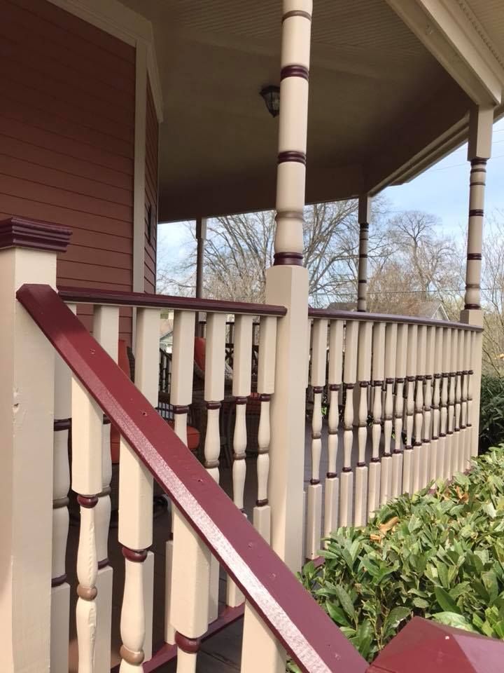 A porch with a white railing and a red railing