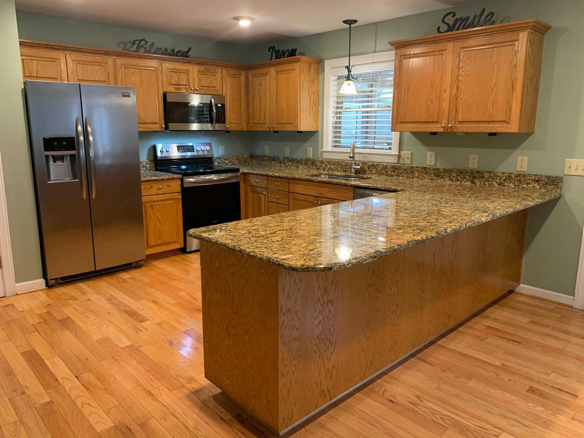 A kitchen with stainless steel appliances and granite counter tops.