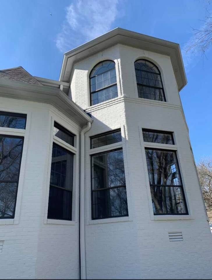 A white house with black windows and a blue sky in the background.