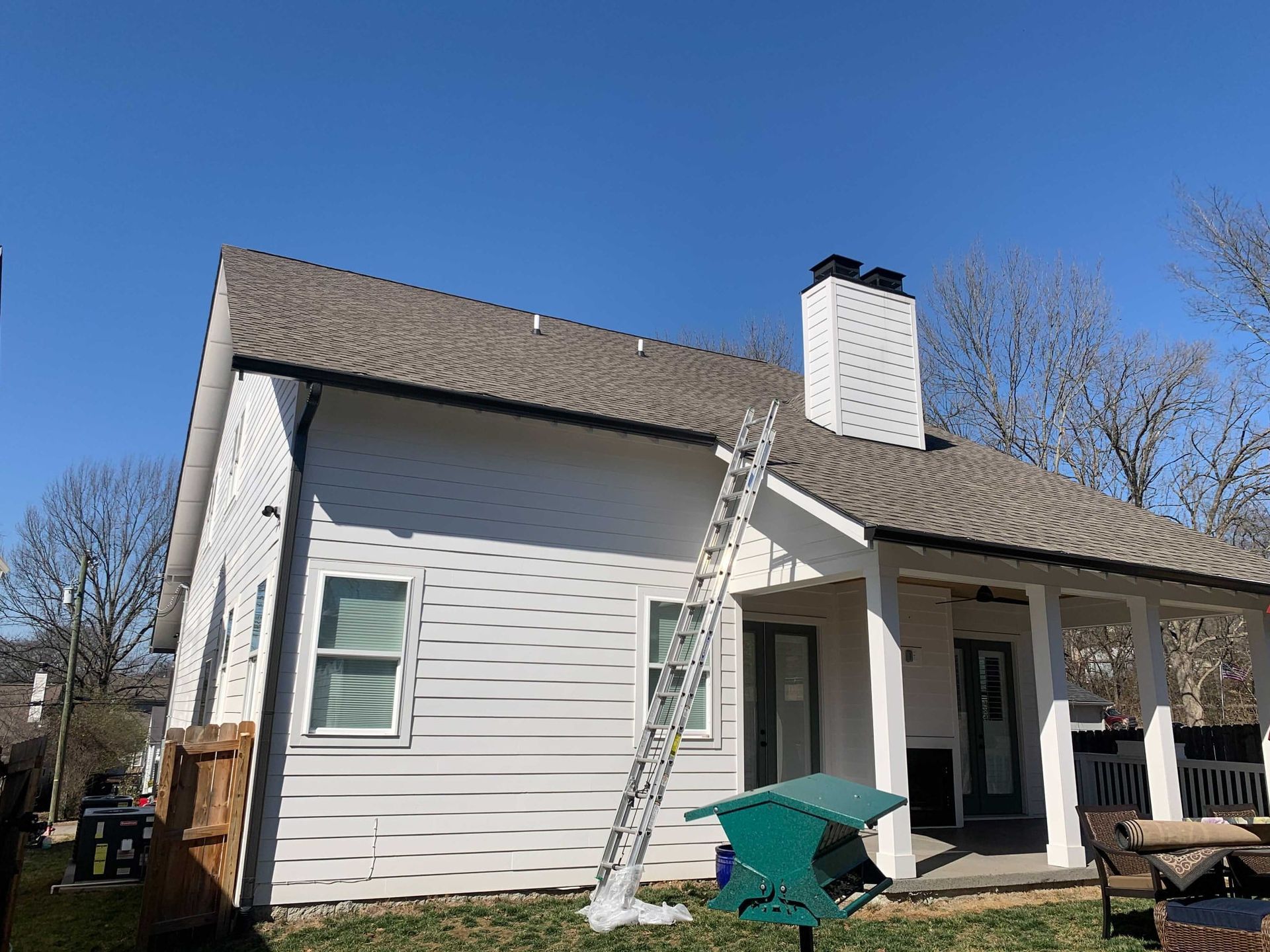 A white house with a ladder on the side of it.